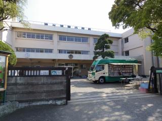 袖ケ浦東小学校の校門から入ってすぐの校舎の前に移動図書館の車が停まっている写真
