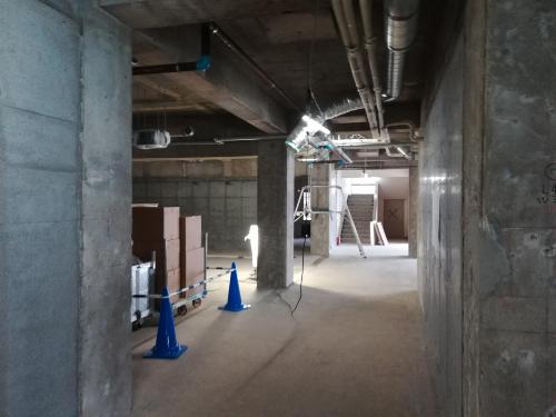 壁や柱がコンクリートで施された建設途中の南館内部の補修の様子の写真