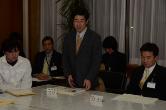 周囲が座って聞いているなか、千葉大学法経学部教授である隊長が挨拶をしている写真