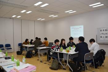 参加者がグループごとに分かれテーブルに設置された椅子に座り話し合っている様子の写真