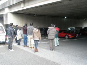 橋の下の車が停まっている付近で説明を受けている参加者の写真