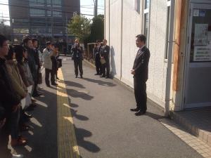 建物の外側で、参加者と向かい合って立っている市長が話をしている写真