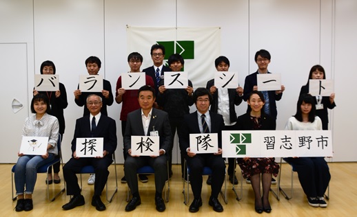 関係者と参加者が前列に6名座り後列に8名立ち、「バランスシート探検隊」と書かれた紙を一文字ずつ持っている集合写真