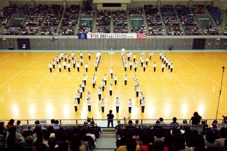 会場の中央でお揃いの白い衣装を着て、3ブロックに分かれ演奏している第二中学校の生徒たちの写真