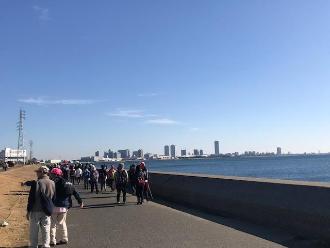 青空の下、海岸沿いの道を歩いている参加者の写真