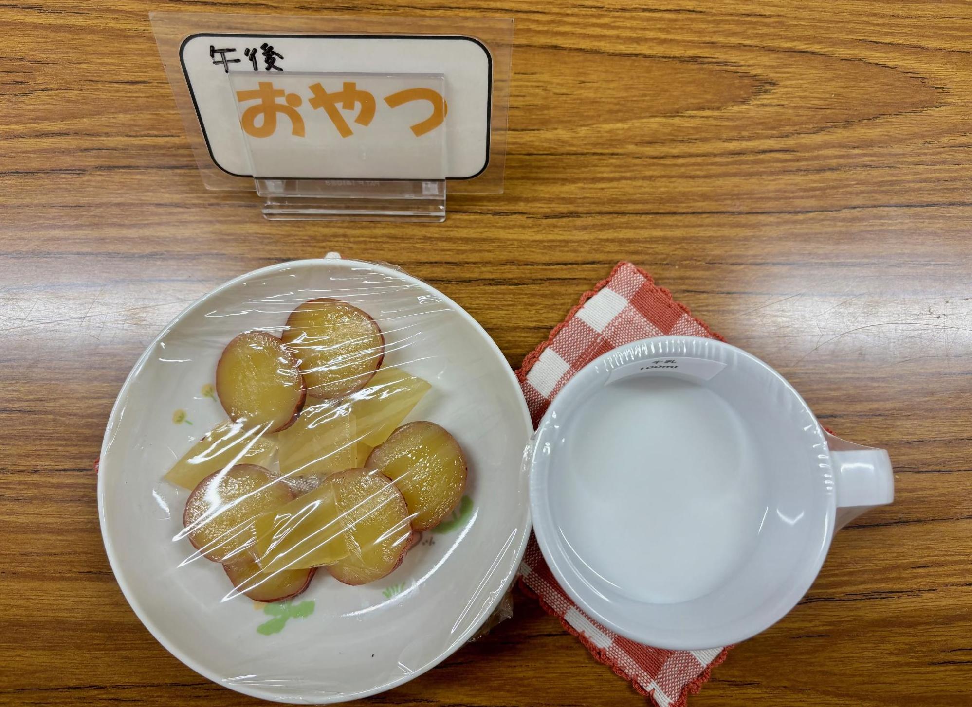 さつまいもの重ね煮、牛乳など、1歳6か月児の午後のおやつの写真