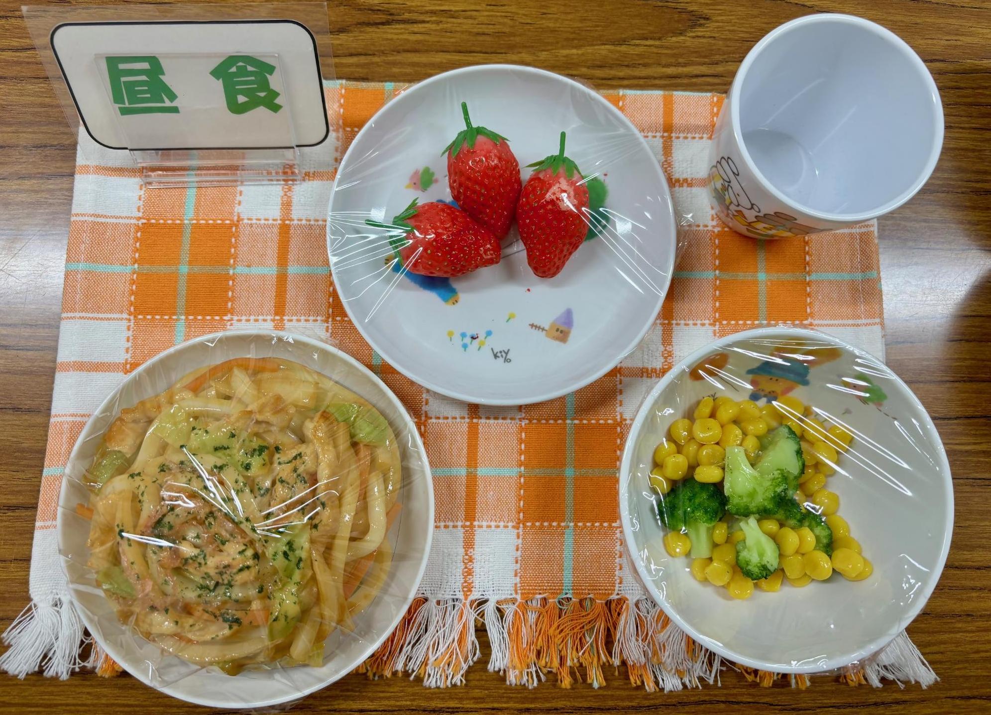 うどん、サラダ、いちごなど、1歳6か月児の昼食の写真