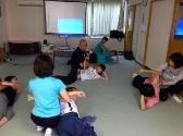 肩肘をついて横になり反対側の腕を回してストレッチしている参加者の写真