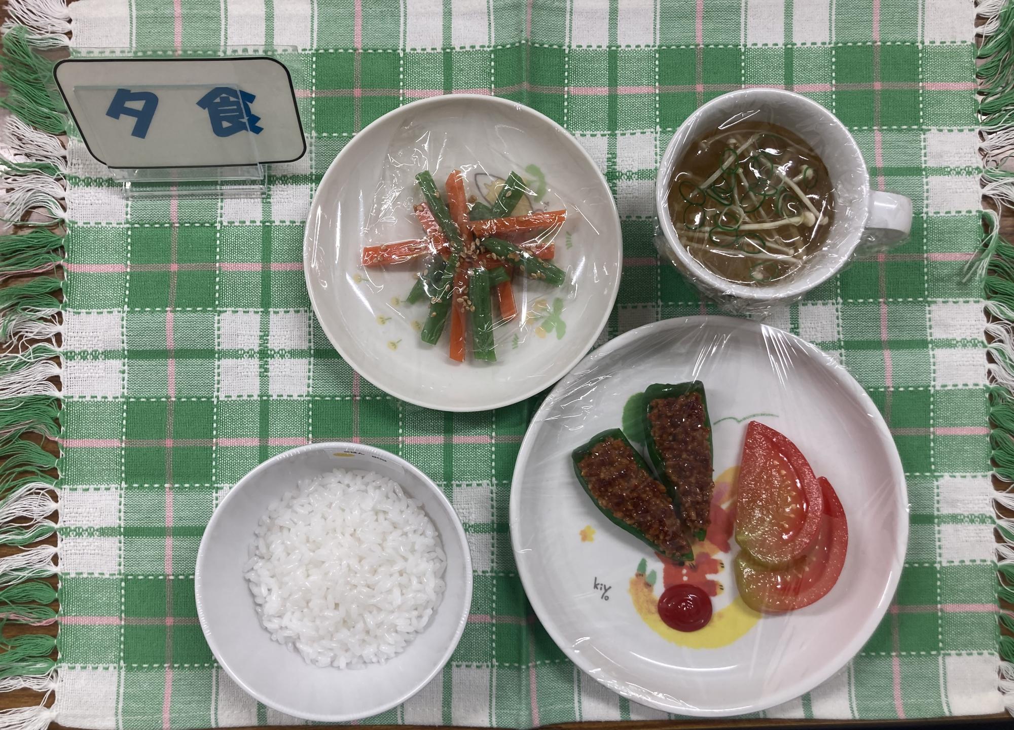 ごはん、ピーマンの肉詰め、サラダなど、1歳児6か月児の夕食の写真