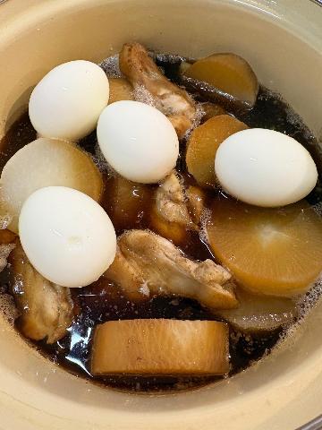 鍋に黒っぽい汁。中には煮込まれている大根の輪切りと手羽元とゆで卵。