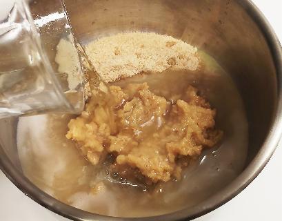 銀のボウルに薄茶色の砂糖、味噌が入っており、上からガラスのコップでビールを注いでいる。