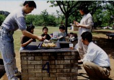 自然に囲まれた香澄公園でバーベキューを楽しんでいる家族の写真