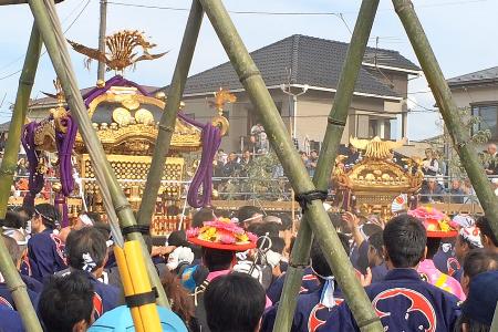 法被を着た大勢の人々が、大宮大原神社神輿(手前)と菊田神社神輿(奥)を担いで、沢山の見物客で賑わっているいる様子の写真