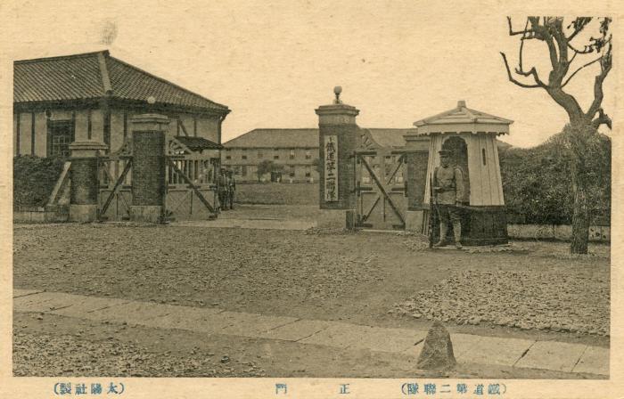 鉄道第二連隊の正門前に1名の兵士が立っているセピア色の風景写真