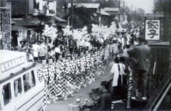 元禄花見踊りを披露している人々と多くの観客の白黒写真