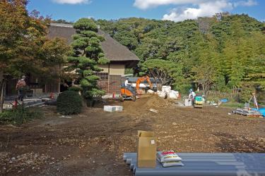 油圧ショベルなどの重機を使い庭園の復旧工事を行っている様子の写真