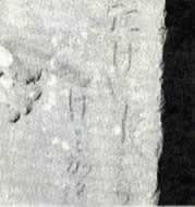 文字が彫られた百番供養塔の部分をアップにした白黒写真