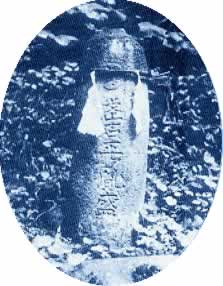 「武石平胤盛」の文字と月星紋が彫られた円柱状の石柱の白黒写真