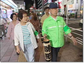 津田沼北部連合町会の人達が歩道を歩きながら自主防犯パトロールをしている写真
