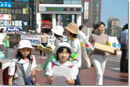子供達がJR津田沼駅で啓発キャンペーンをしている写真