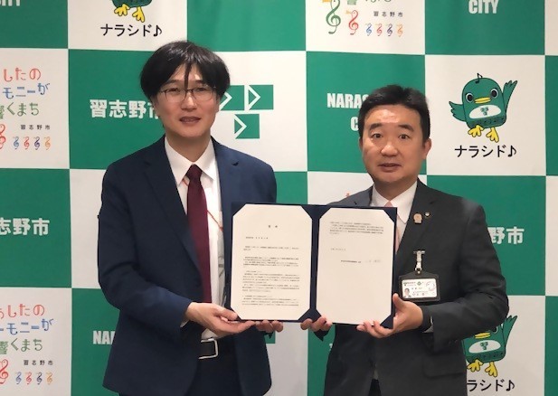 山岸会長から答申書を受け取る宮本市長