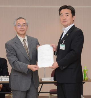 大島会長（左）が宮本市長（右）へ答申書を手渡している写真