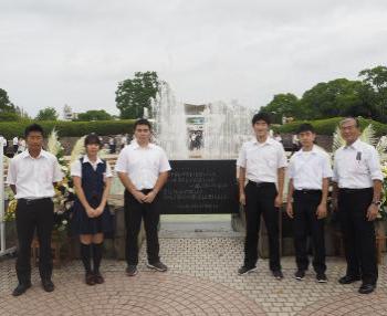 噴水の前で5名の男性1名の女性の平和市民代表団の皆さんの集合写真