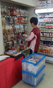 商品の陳列をしている男子中学生の写真