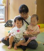 保育者と一緒に子どもが絵本を見ているところ