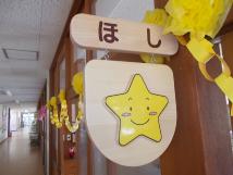 部屋の入り口の木製の板に星の絵が描かれているほし組保育室の写真