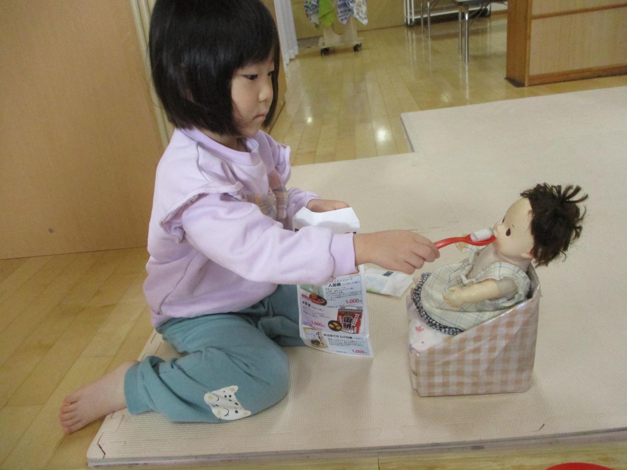 赤ちゃん人形に、ご飯をあげています。