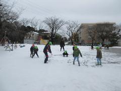 降り積もって雪で遊んでいる子供たち