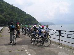 湖沿いに自転車を置いて休憩している参加者の子供たちの写真