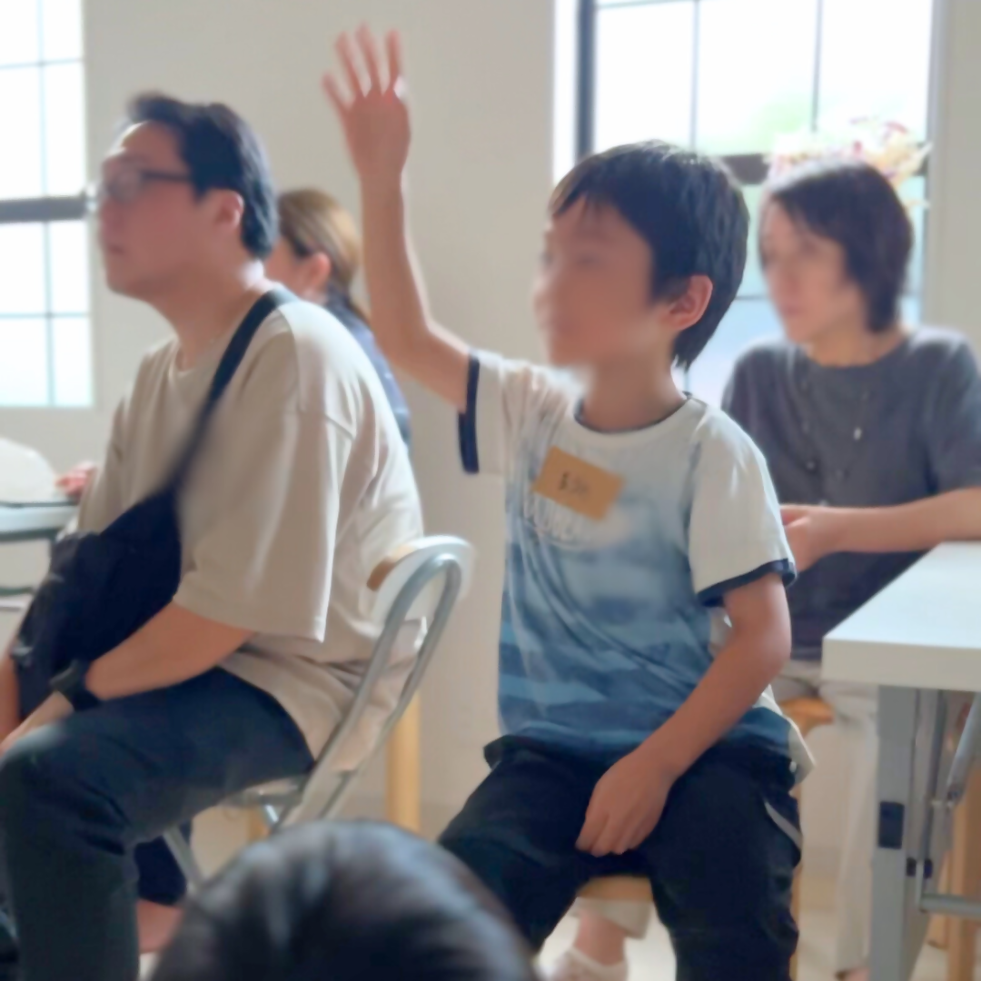 手を上げて発表している少年