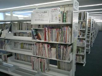 中央図書館内の本棚の一角に「リサイクル資料コーナー」の紙が貼られているスペースに書籍が並んでいる写真