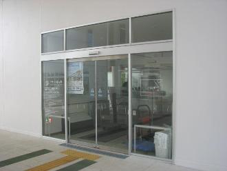 白い外壁にガラスの自動ドアがある中央図書館入口の写真