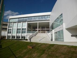中央に階段がある2階建てのL字型の構造で、外壁がガラス張りになっている中央図書館の外観写真