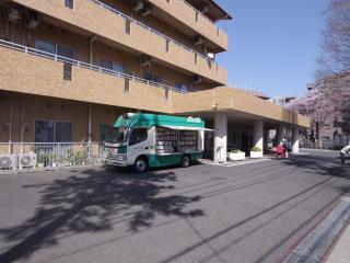 新栄1丁目習志野偕生園前に停まっている、移動図書館の車の開いた横のドアからたくさんの本が見えている写真