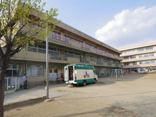 鷺沼小学校に後ろのドアが開いた移動図書館の車が停まっている写真