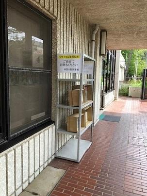 東習志野図書館の建物の軒下に設置されたラックに「リサイクル資料配布」と書かれた紙が貼って書籍が並んでいる写真