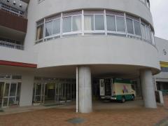 津田沼小学校の円形の校舎の屋根下に移動図書館の車が停まっている写真