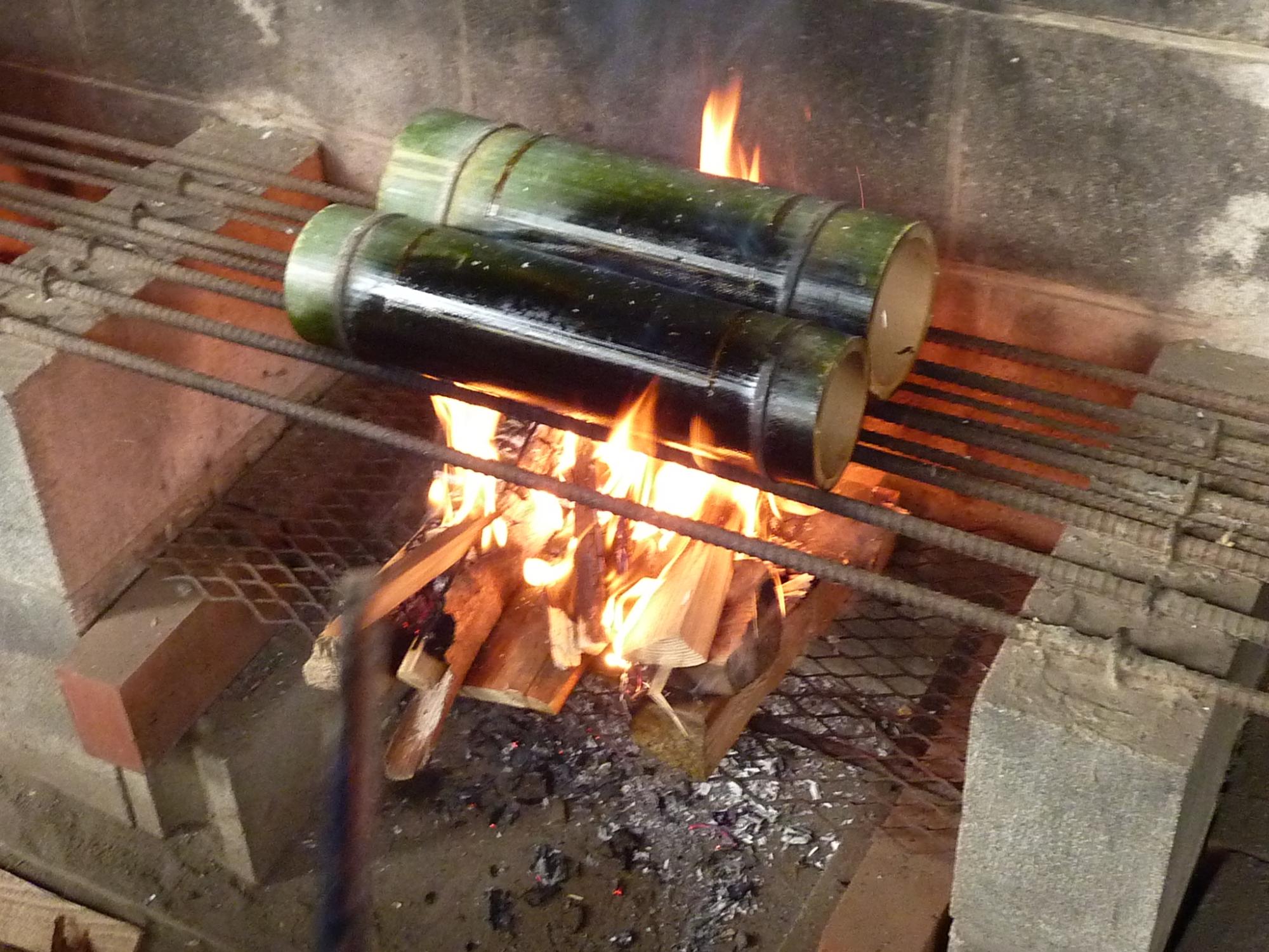 かまどで加熱されている竹飯ごう