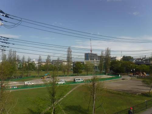 緑色の柵で囲まれた仮設駐車場を高台から撮影した写真