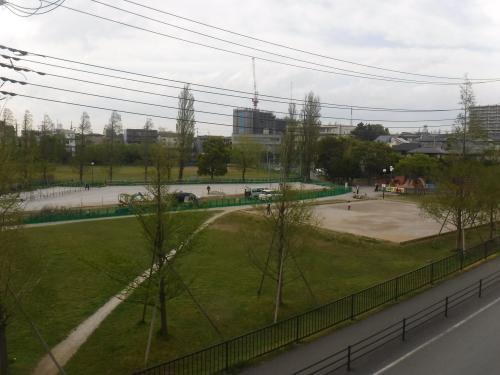 周囲を緑色の柵の囲いを設置した仮設駐車場の写真