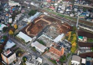 解体作業が始まり地面の土などがむき出しになっている新庁舎建設工事現場を上空から撮影した写真