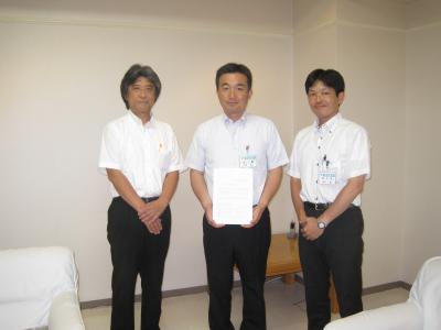 中央の宮本市長が資料を手に持ちその両サイドに廣田委員長、西村副市長が立っている写真