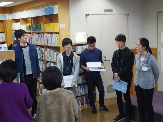 本棚の前で参加者が輪になって集まり話しをしている写真