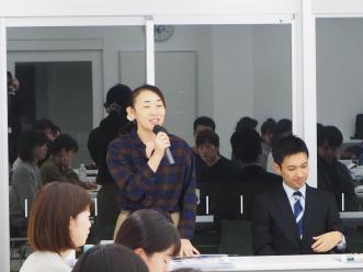右手にマイクを持ち話しをしている吉田公認会計士の写真