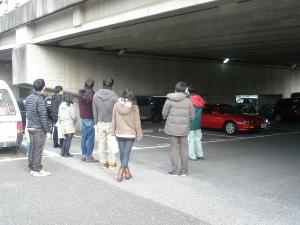 橋の下の車が停まっている付近で説明を受けている参加者の写真