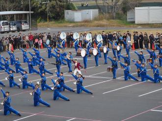 青いスーツに身を纏った生徒たちが楽器を手にポーズをとっている写真